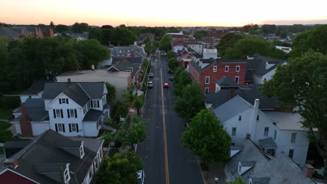Aerial-reverse-dolly-of-small-town-America-street-with-car-driving