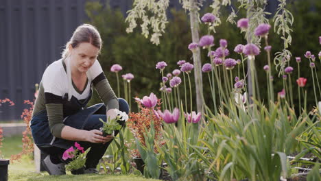 Una-Joven-Está-Plantando-Flores-En-El-Patio-Trasero-De-La-Casa.