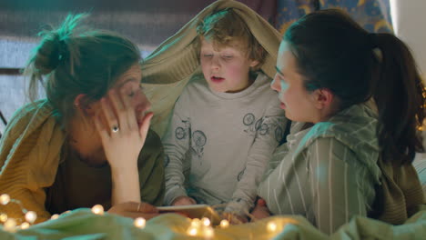 lesbian couple talking with little son in bedroom