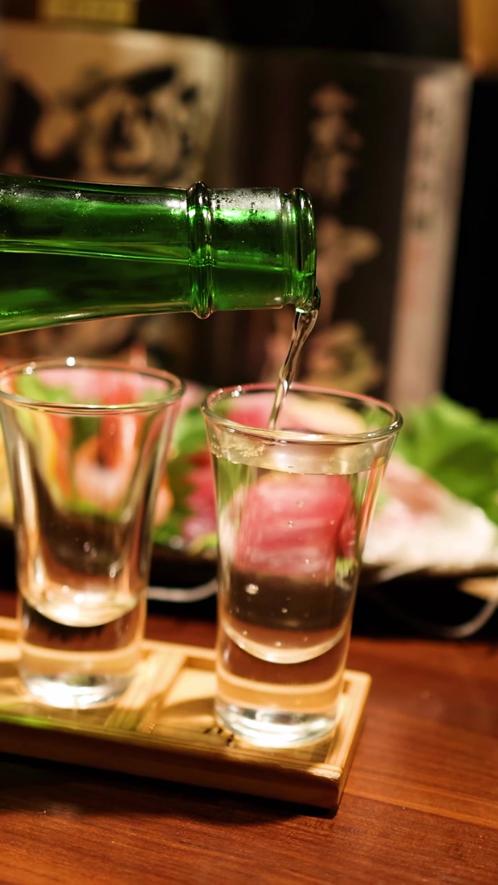 Sequenza di sake versato in più bicchieri