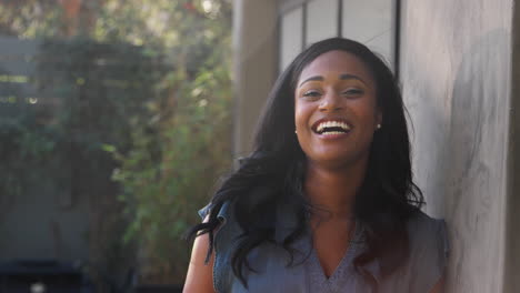 Retrato-De-Una-Mujer-Afroamericana-Sonriente-En-El-Jardín-De-Casa-Contra-El-Sol-Abrasador