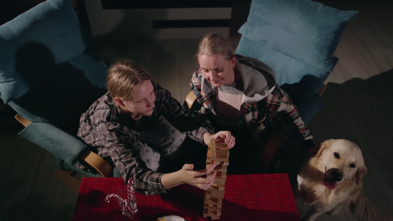 나무 블록 과 과자 를 가지고 놀고 있는 자매 들