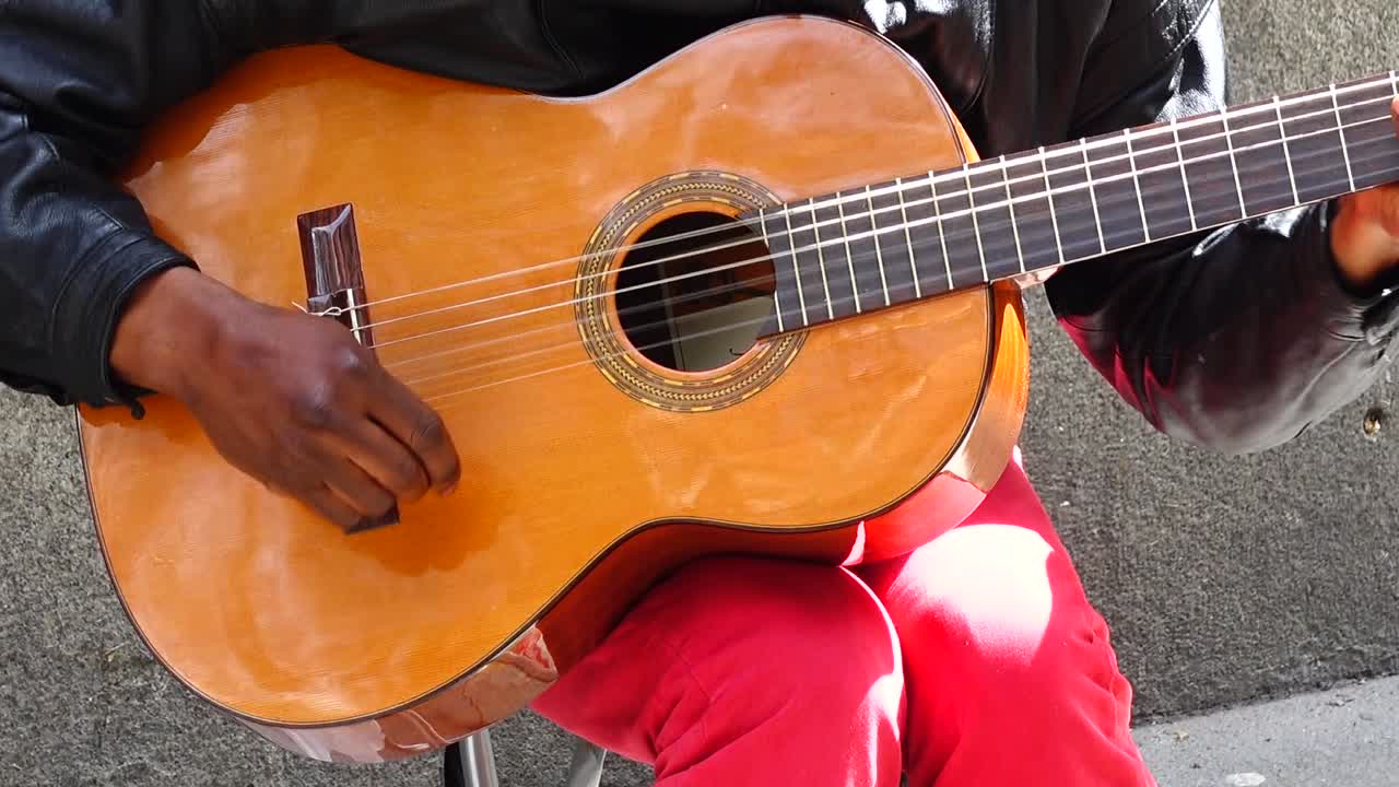 Il musicista suona la chitarra e canta per strada.