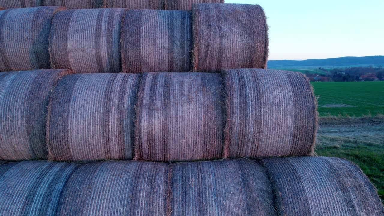 las balas de heno, apiladas en una pirámide, secas en el campo al atardecer.