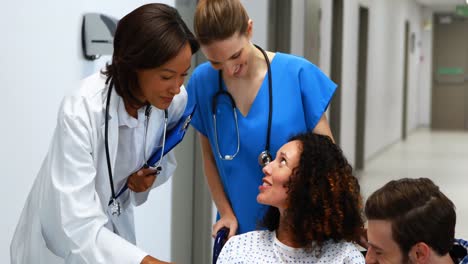 doctor interacting with pregnant woman in corridor