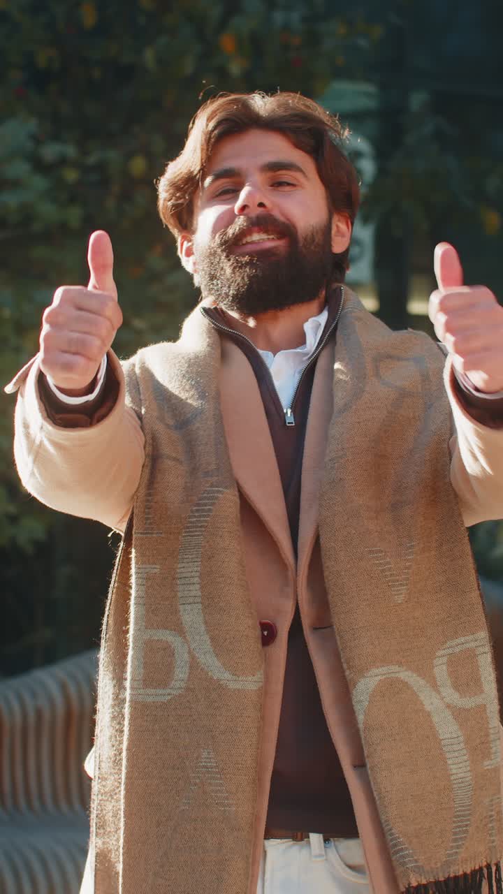 Happy indian business man showing thumb up gives positive reply standing on downtown city street