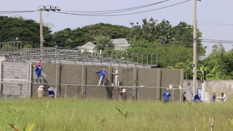 equipo de trabajadores que erigen andamios en un sitio de construcción.