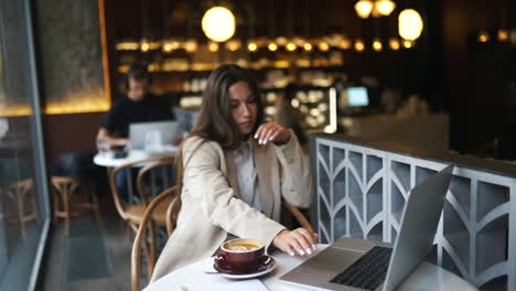 woman working on laptop in a coffee shop