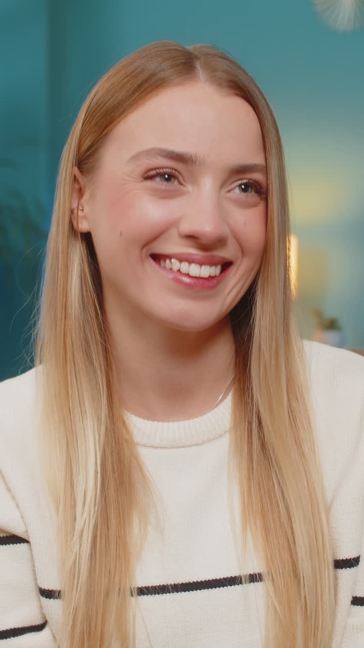 Caucasian woman paying purchase on sofa with mobile phone credit card smiling successful indoors