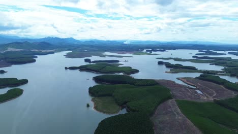 smooth pan right showing lush islands and reflective lake surface under dramatic sky in vietnam