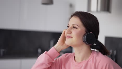 Retrato-De-Mujer-Sonriente-Bailando-En-La-Cocina-Con-Auriculares