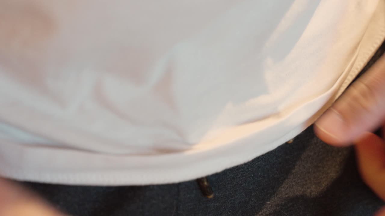 Close-up of hands tying the drawstring of jogging pants before a workout. Moment of motivation and preparation for fitness or training