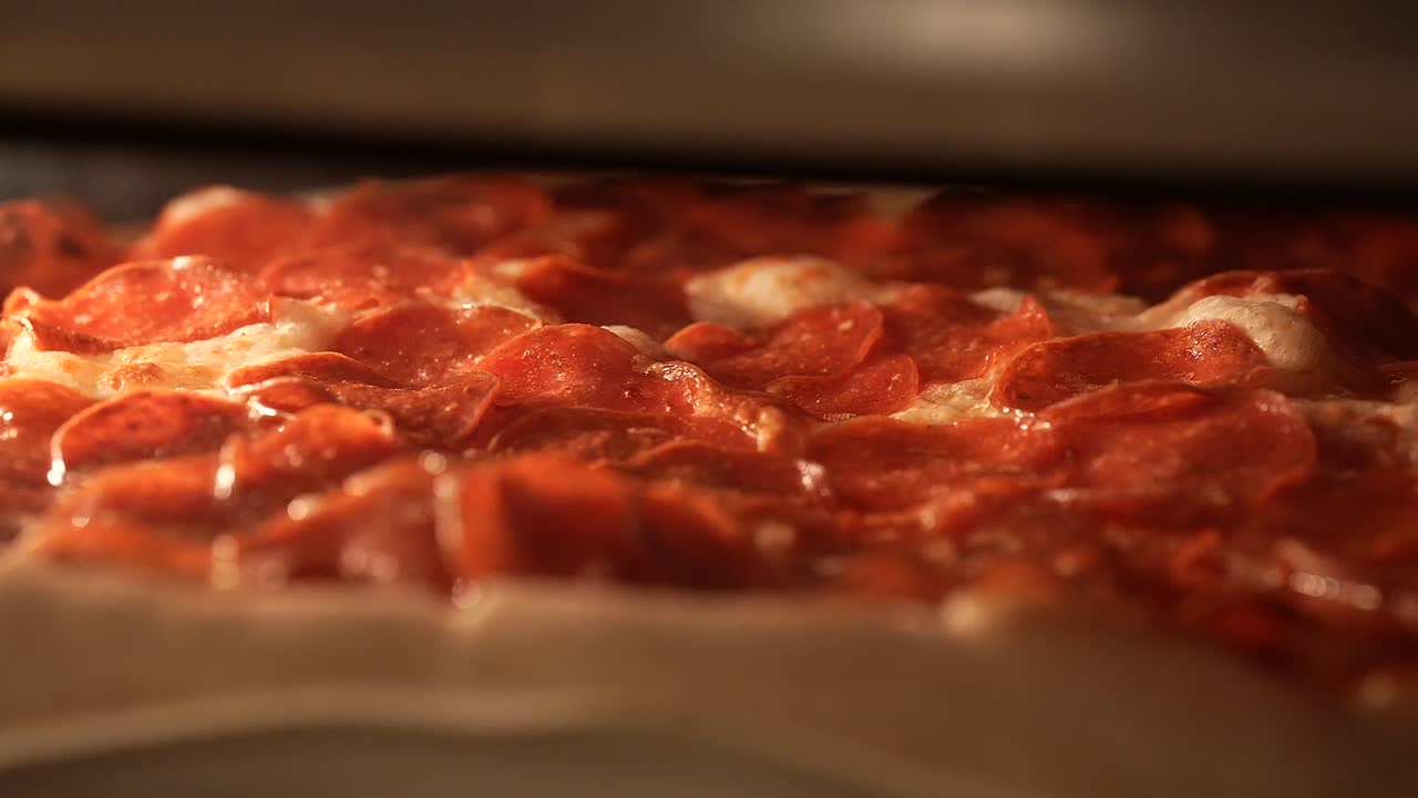 vista macro de una pizza casera de pepperoni horneada en el horno con el queso burbujeando mientras se derrite