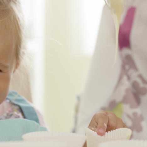 niña riendo tocando soportes para panecillos vacíos