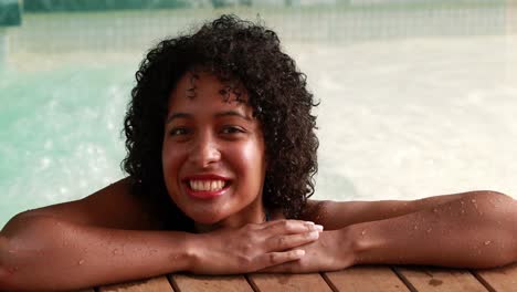 gorgeous woman relaxing in hot tub and smiling at camera