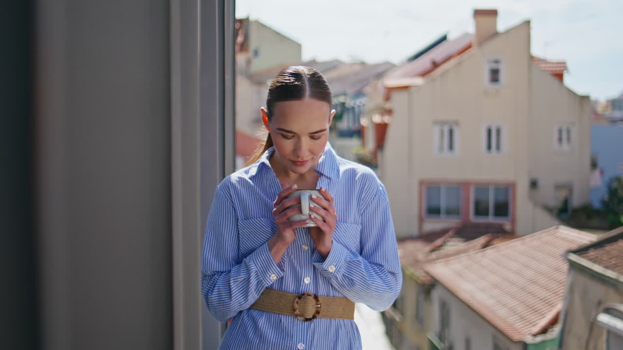 Closeup woman smelling coffee aroma at cityscape place. Serene model at terrace