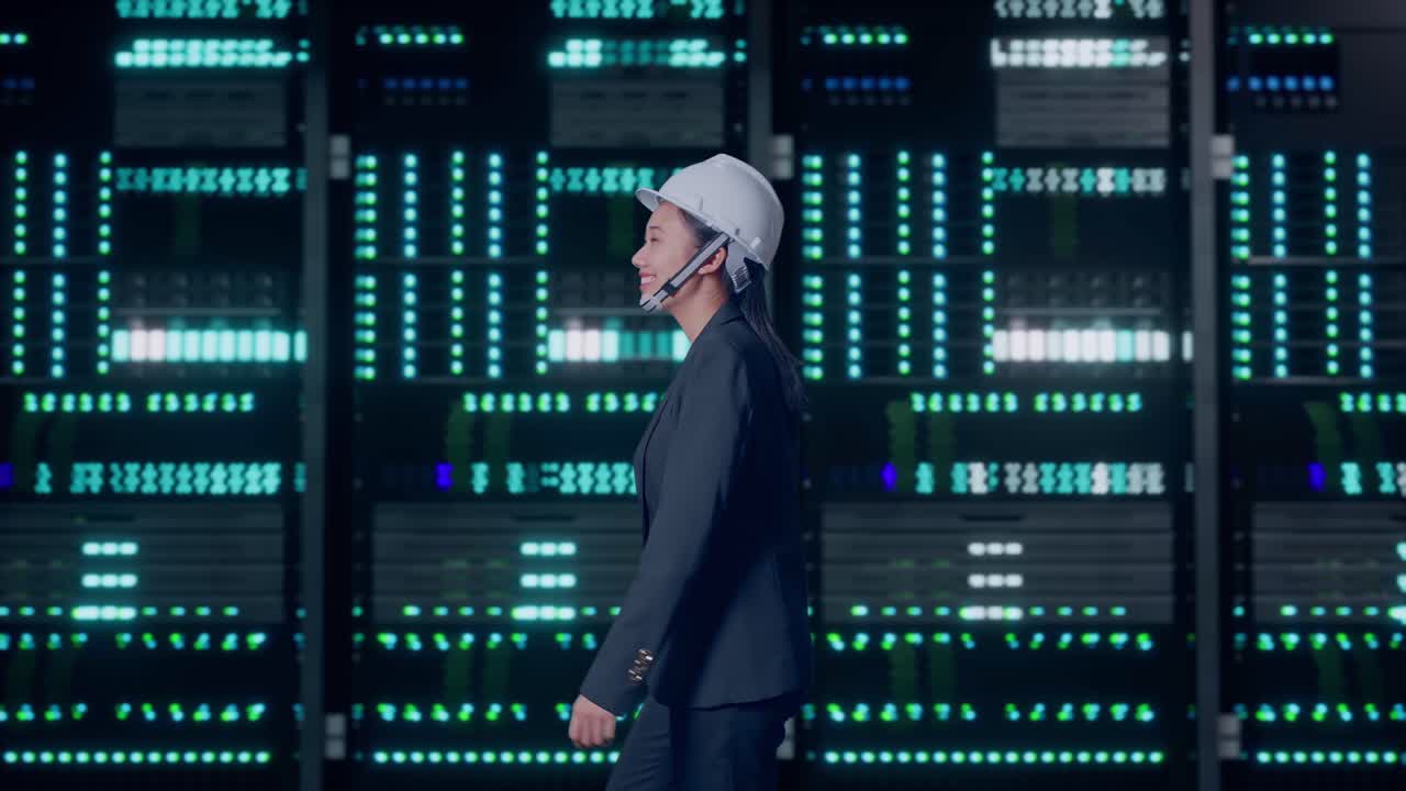 Side View of Asian Businesswoman Walking and Smiling in Server Room Data Center