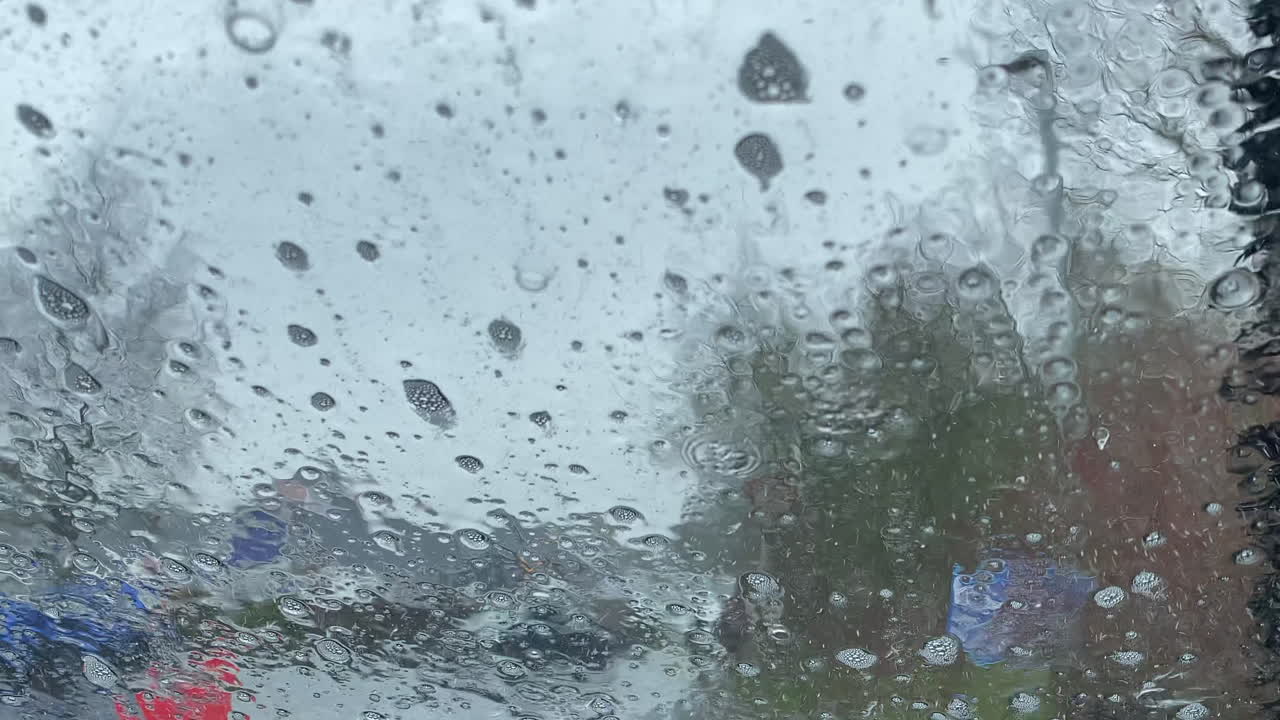 유리를 따라 흐르는 패턴을 만드는 자동차의 앞 유리를 통해 볼 때 세차장을 통한 자동 운전