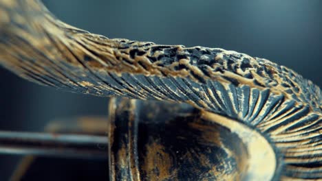 A-vertical-close-up-macro-shot-of-a-spartan-face-design,-warrior-metal-bronze-helmet,-on-a-rotating-stand,-studio-lighting,-Full-HD-video,-super-Slow-Motion-120-fps