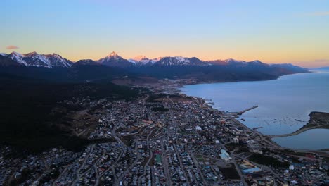 Disparo-De-Un-Dron-Volando-Sobre-Ushuaia,-Argentina-Al-Atardecer-Hacia-Las-Montañas-De-Los-Andes