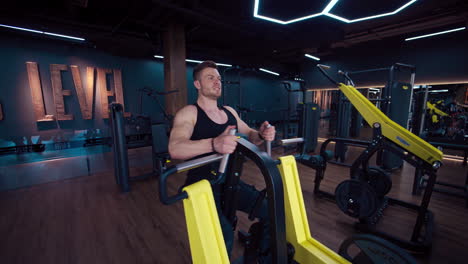 fitness man training exercise in gym. athletic young male does exercises at gym