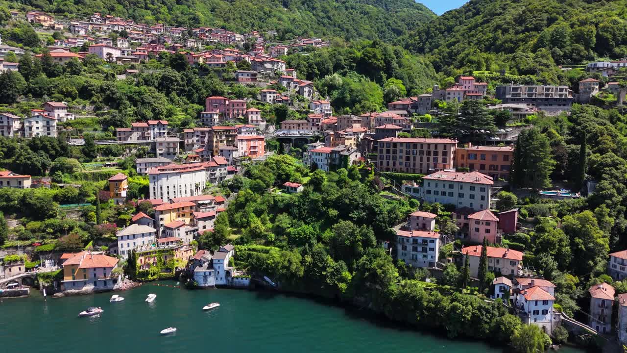 Nesso village showcasing traditional houses cascading down the hillside to Lake Como, surrounded by lush green mountains and reflecting Italian charm, drone establishing shot, Lombardy, Italy