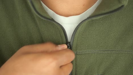 man zipping up a green fleece jacket