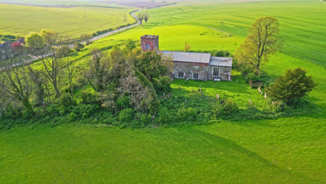 Burwell-village,-a-medieval-market-town-previously,-is-depicted-through-drone-footage,-highlighting-country-fields,-aged-red-brick-homes,-and-the-disused-Saint-Michael-parish-church-on-Lincolnshire