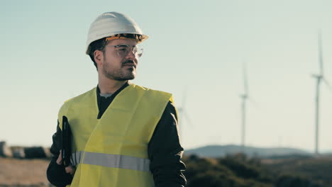 a white-helmeted engineer near wind turbines, symbolizing the importance of renewable energy for a sustainable future