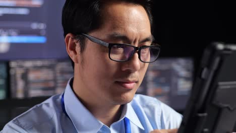 man concentrating on tablet in a night work environment