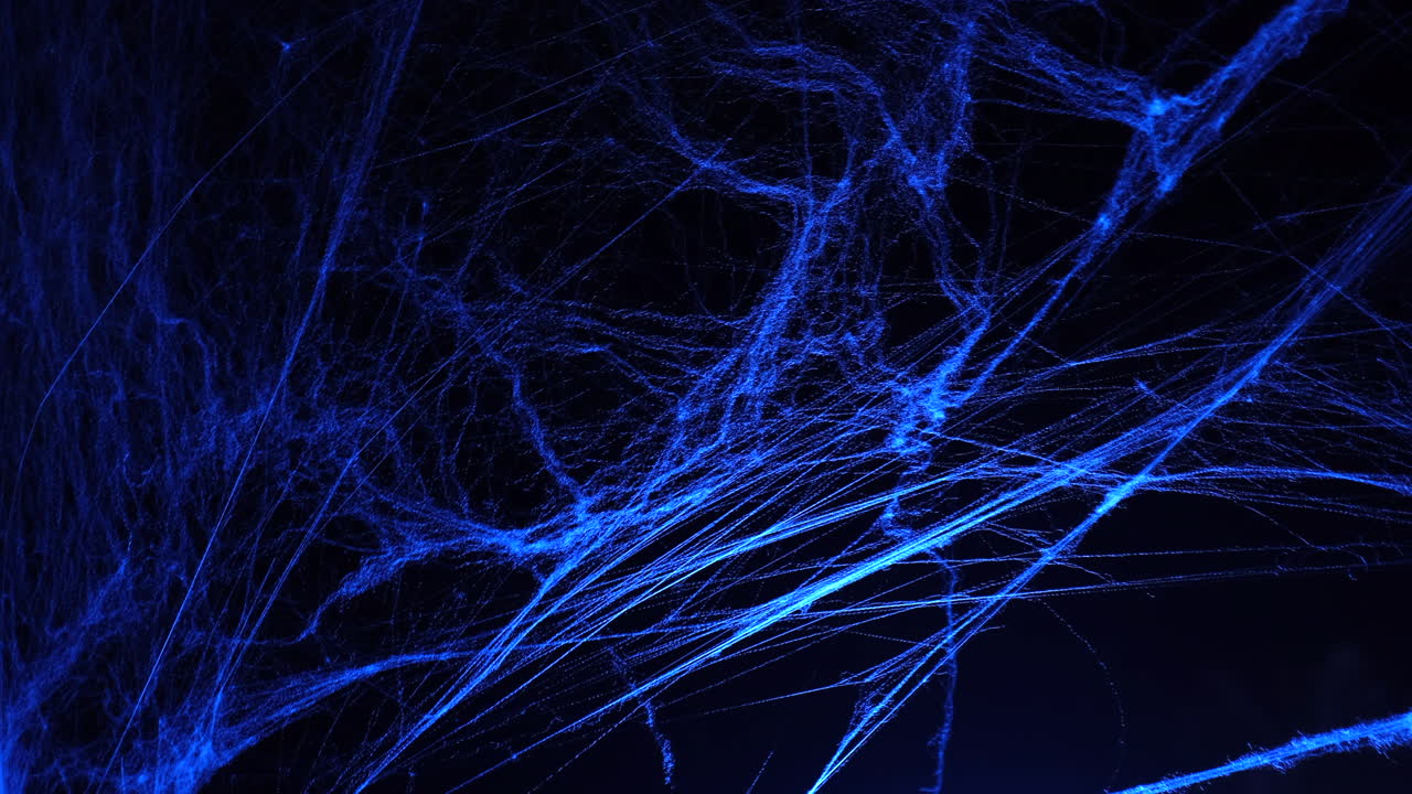 Halloween spooky blue spider web in the darkness