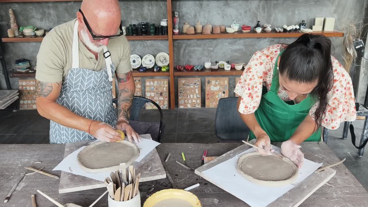 Un hombre y una mujer crean cerámica juntos en un taller creativo