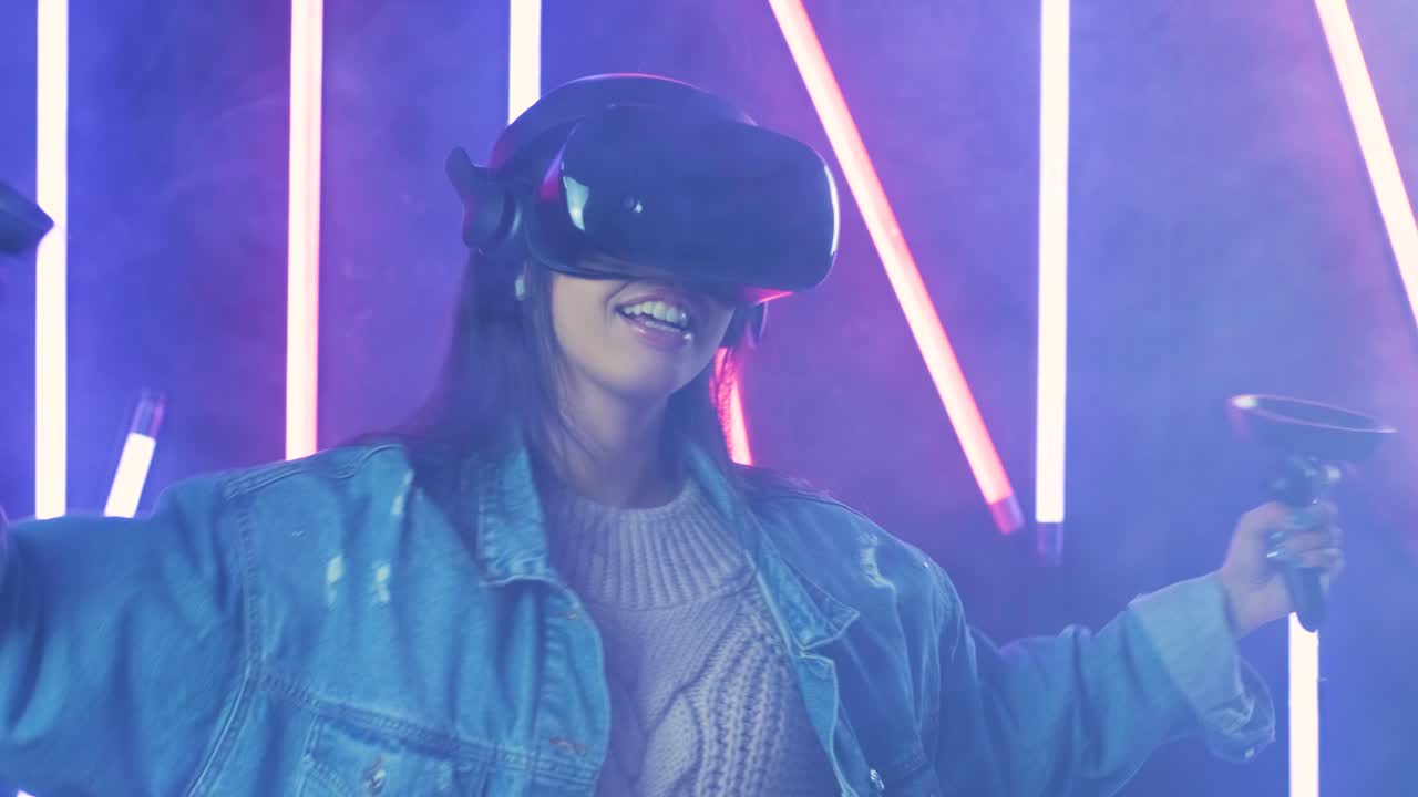 giovane donna che balla con le cuffie vr. casco di realtà virtuale su sfondo di luce a colori fumo
