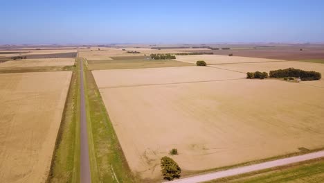 aerial view of highway road through wheat fields landscape - drone shot