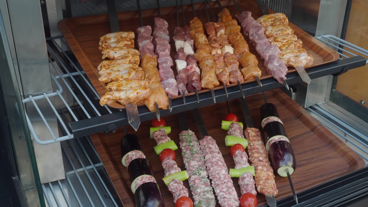 Primo piano di una varietà di spiedini di carne su una griglia