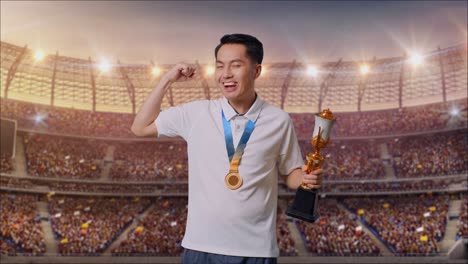 スタジアムでトロフィーとメダルを持って勝利を祝う男性
