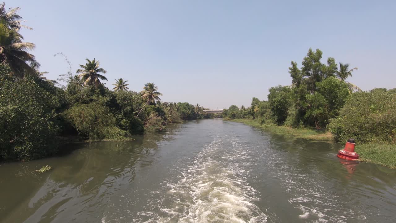 vista de barco navegue a lo largo de un canal tradicional con vegetación exuberante en el distrito de alappuzha, kerala