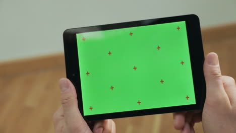 manos masculinas sosteniendo la tableta. hombre tocando la tableta de cerca pantalla verde tableta