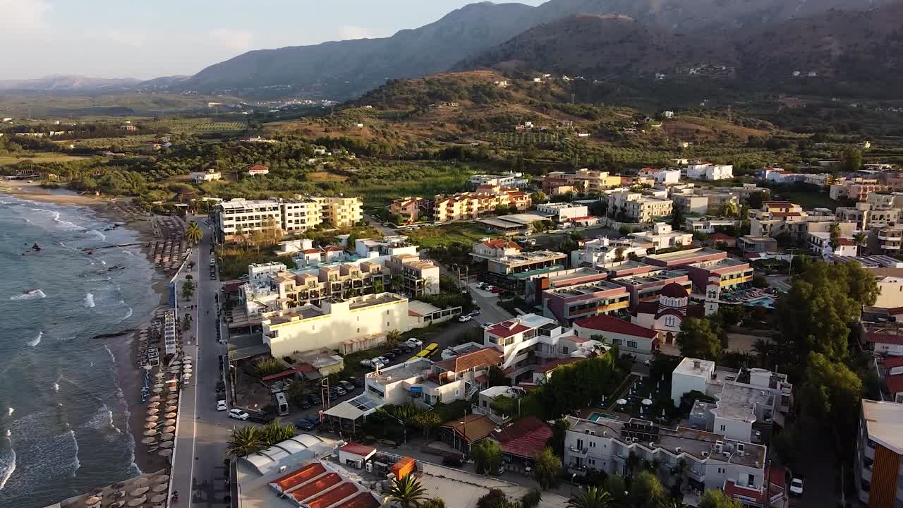 Crete township and mountains in background during sunset, aerial drone view