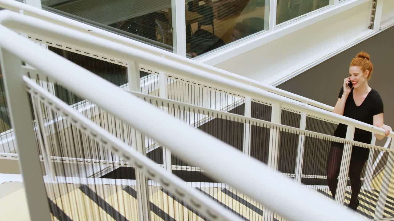 상층 4k로 이동하는 동안 휴대 전화로 이야기하는 사업가