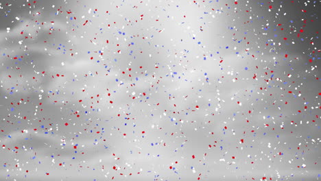 confeti rojo, blanco y azul cayendo en animación de celebración sobre fondo gris