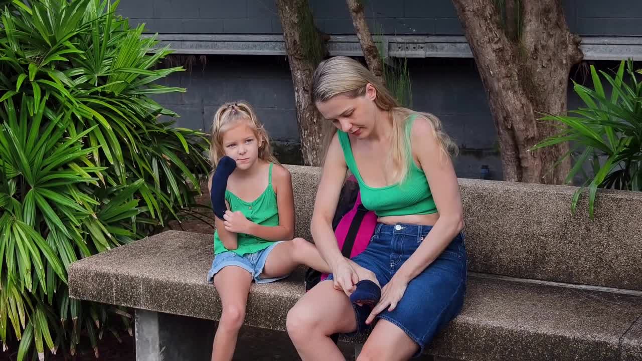 어머니 와 딸 이 야외 에서 양말 을 입고 있다