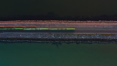 aerial top-down view of irish dart crossing broadmeadow viaduct in the evening
