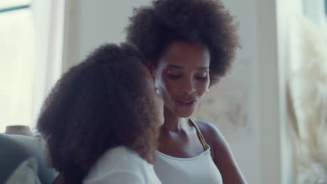 african american mum and child spending time at home, sitting and talking