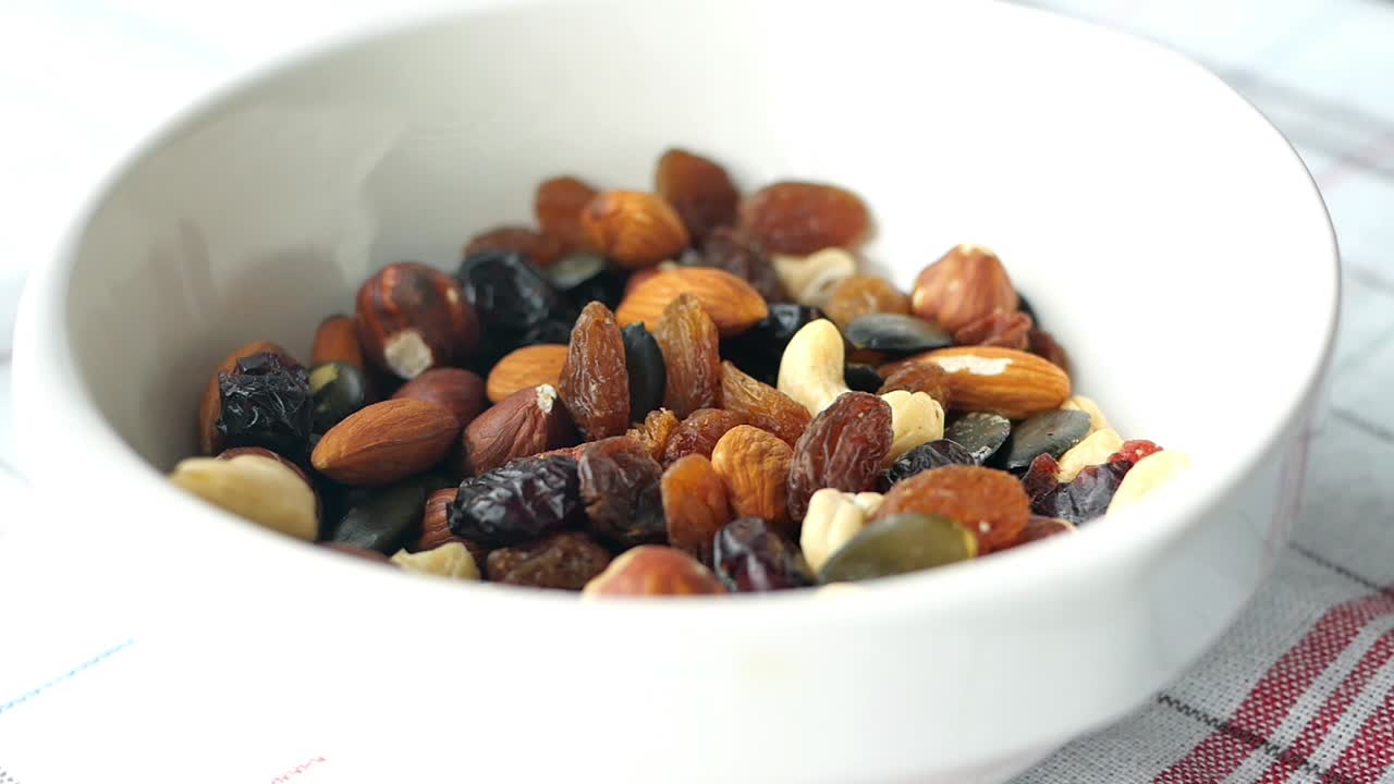 Slow motion di frutta secca mista che cade in una ciotola