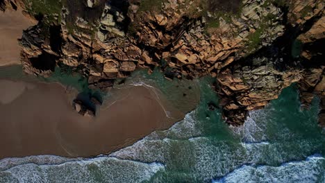 cornwall's beach with rocky cliffs along the cornish coastline from an aerial rotating drone spiraling downward, england, uk