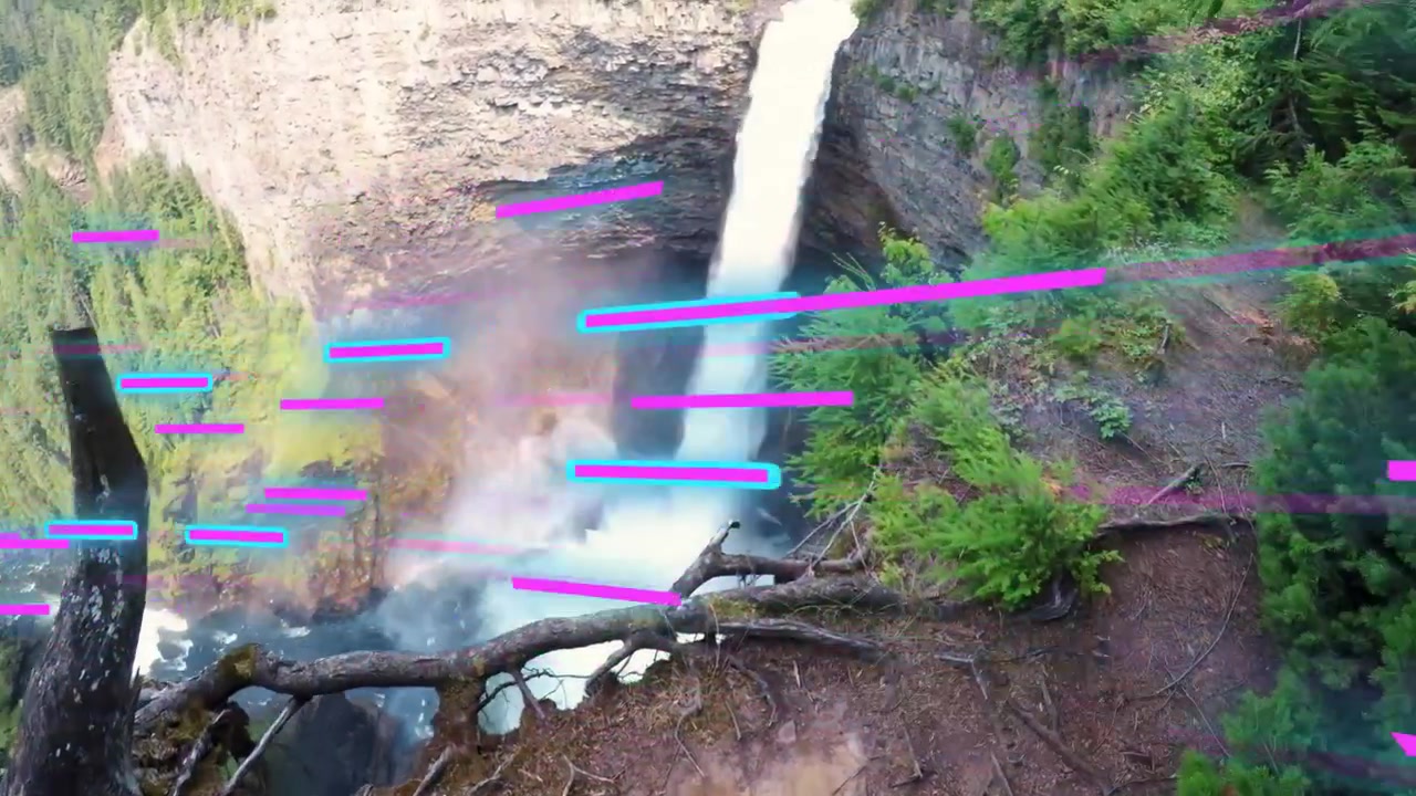 Donna di mezza età che tiene una videocamera, indossando una maglietta a maniche corte, filmando una cascata su un sentiero con sovrapposizioni al neon.