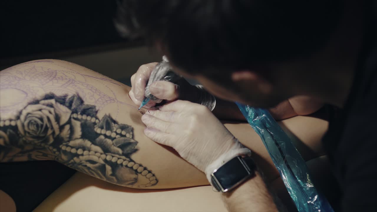 Tattoo Artist Working on a Leg Tattoo