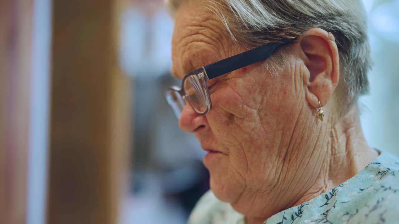 Anziana donna con espressione dolce. Donna anziana con rughe visibili e sguardo tenero in ritratto. Primo piano dettagliato di un'anziana nonna che mostra un'espressione dolce e texture della pelle.