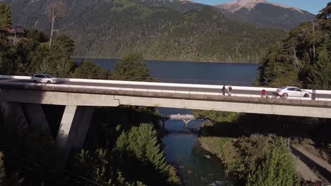 bridge over correntoso river with the nahuel huapi lake and the mountains in the background